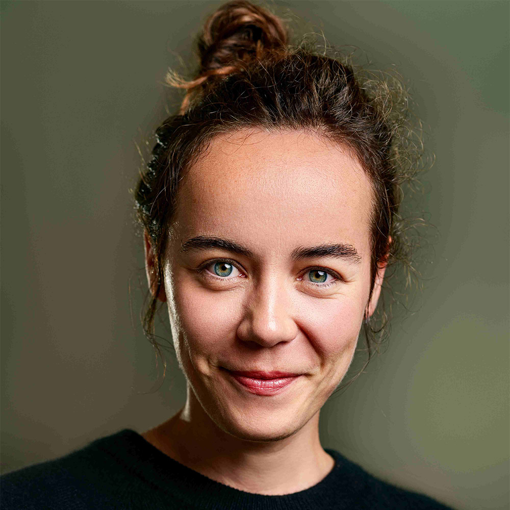 Portrait Claudia Jork, sie schaut offen und direkt in die Kamera, sie lächelt leicht